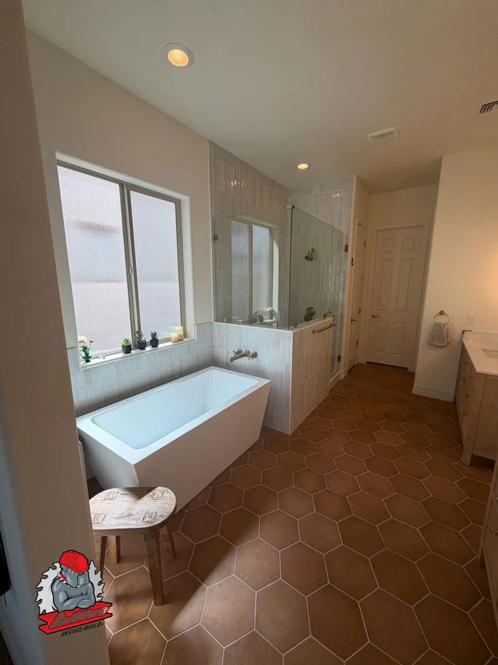 Primary bathroom with freestanding soaking tub on terracotta hexagon tile