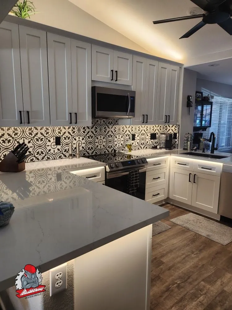 White kitchen with patterned cement-tile backsplash and under-cabinet lighting