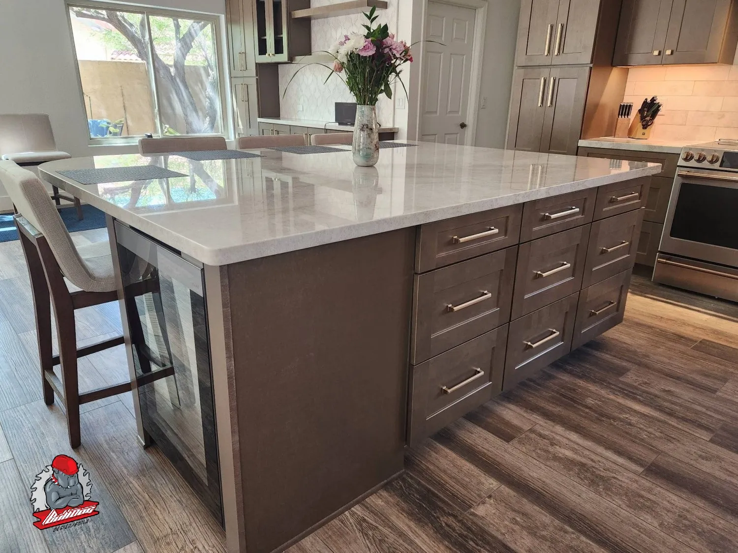 Kitchen with oversized quartz island, bar seating and gray cabinetry