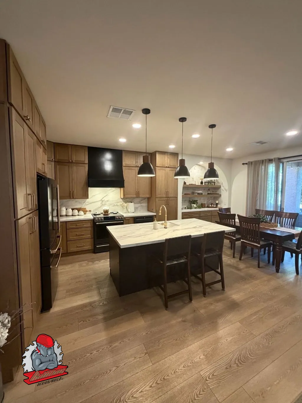 Contemporary kitchen with walnut cabinetry, black island and pendant lighting