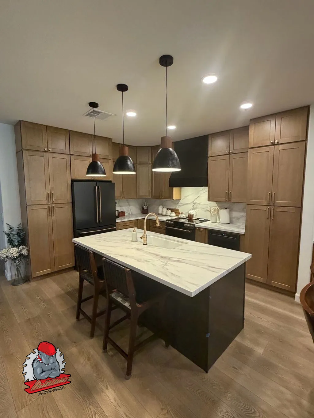 Warm walnut shaker kitchen with marble waterfall island and black pendants